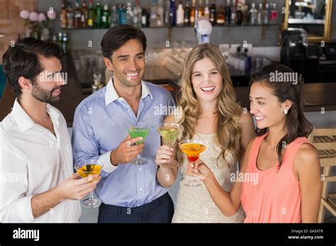 Happy friends holding cocktail glasses Stock Photo - Alamy