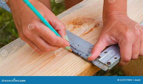 Woman Carpenter Makes Pencil Markings on a Wooden Board. DIY in the ...