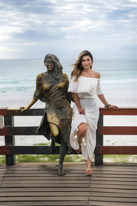 Flávia Alessandra posa ao lado de estátua em sua homenagem, em Arraial