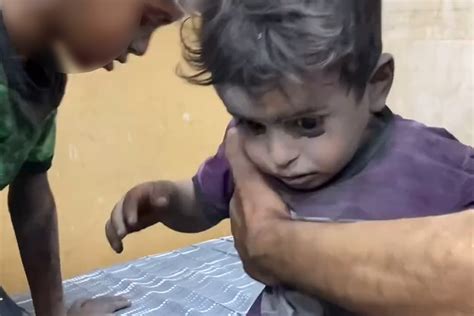 gaza shell shocked child silently seeks reassurance   brother