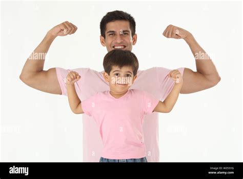 Father and son flexing muscles Stock Photo - Alamy