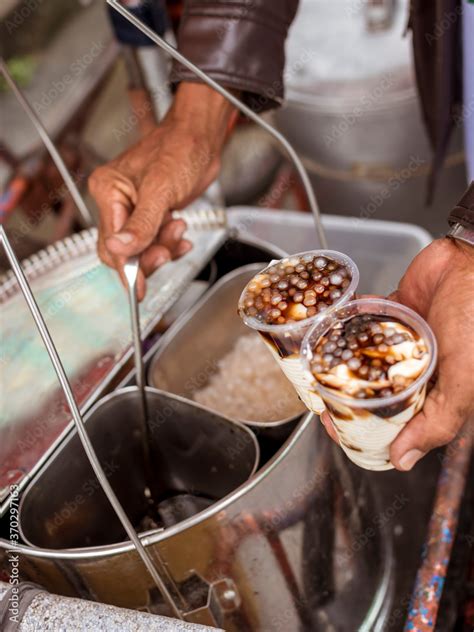 vendor adding generous servigs  sugar syrup   cups  taho taho