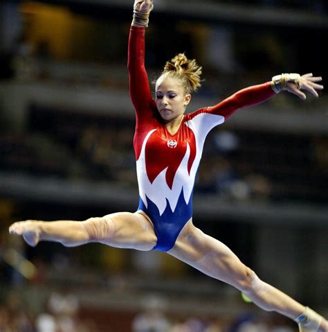 Gymnast doing splits on balance beam during competition women's
