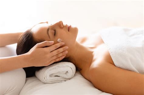 Premium Photo | Hands massaging womans head and temples at spa salon