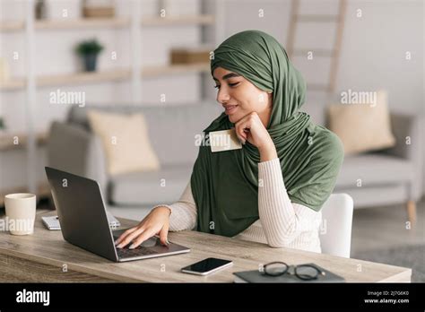 Paiement sans espèces. Jeune femme arabe dans hijab tenant une carte de ...