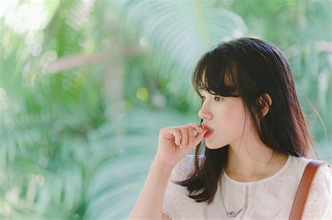 Woman Suck Thumb Finger Near Green Tree · Free Stock Photo