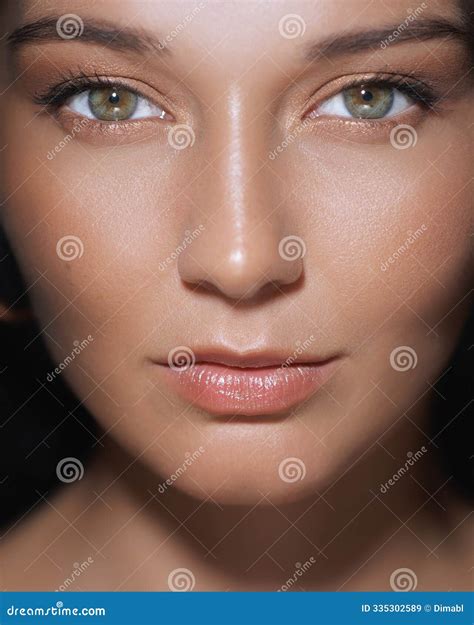 Close-Up Portrait of Woman with Radiant Skin and Nude Makeup Stock