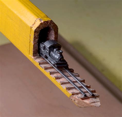 A Carved Graphite Train on Tracks Emerges from Inside a Carpenter's ...