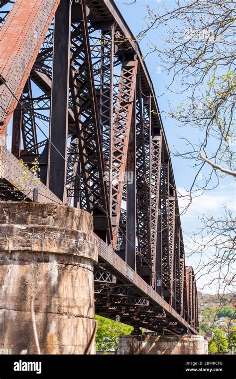 A steel railroad trestle bridge with concrete abutments on a sunny ...