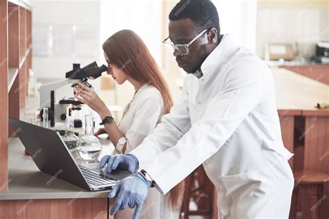 Assistente de laboratório com lâmpada de vidro de laboratório de ...