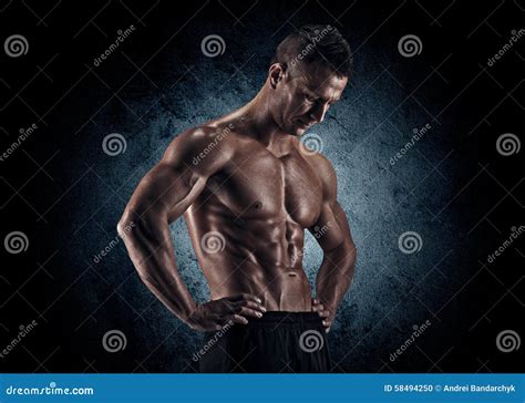 Uomo Muscolare in Studio Su Fondo Scuro Fotografia Stock - Immagine di ...