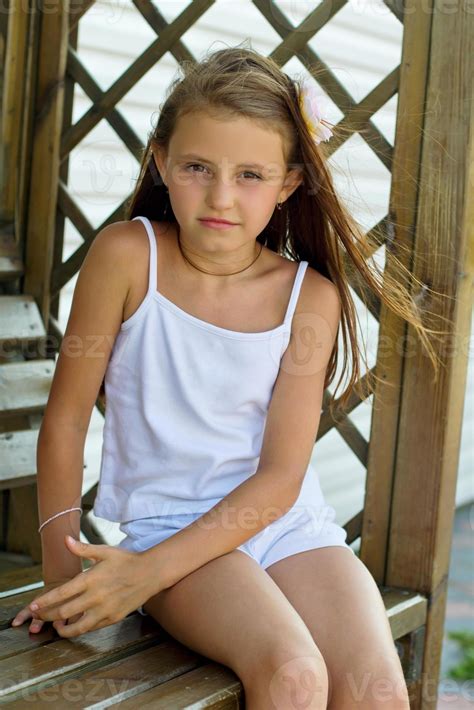 girl sitting on a wooden bench 18942069 Stock Photo at Vecteezy