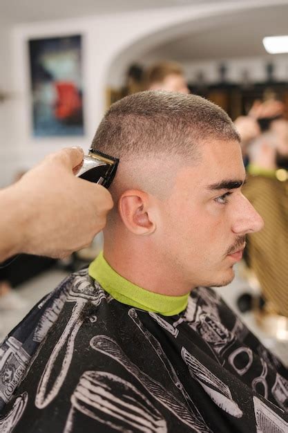 Premium Photo | Side view of male client sitting in barber shop hair ...