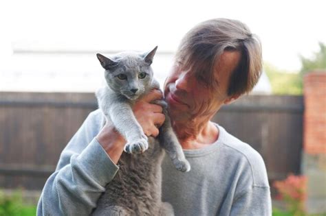 Premium Photo | Smiling man holding cat outdoors