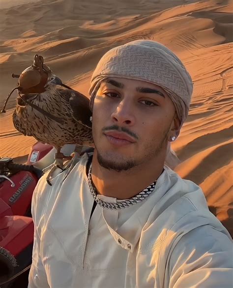 a man with a bird on his shoulder in the desert