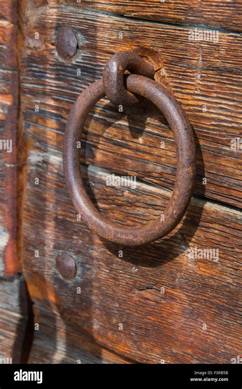 Old rusty door handle ring shaped on a wooden door Stock Photo - Alamy