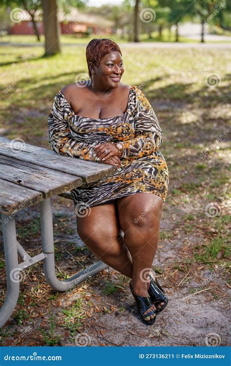BBW Big Black Beautiful Model Sitting on a Park Bench Outdoors Stock ...