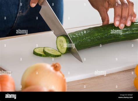 close   womans hand chopping vegetables  knife  kitchen