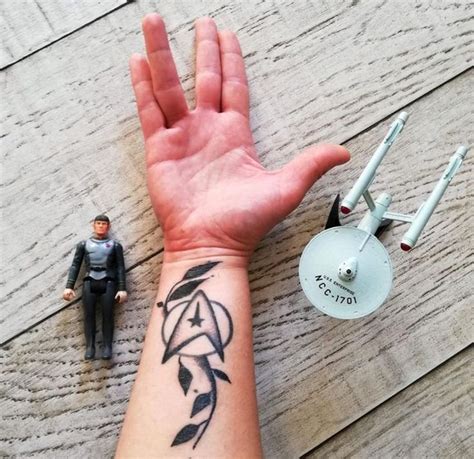 a hand with a tattoo on it next to a toy and a figurine