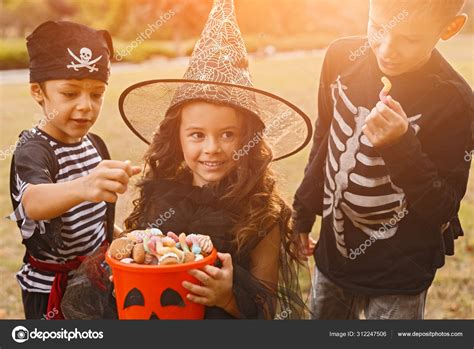 Happy kids in Halloween costumes with candy collector Stock Photo by ...