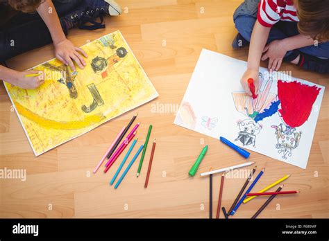 Two kids drawing together on sheets Stock Photo - Alamy