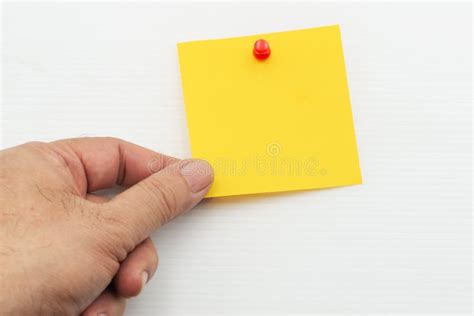 Hand Holding Yellow Post Note Paper Attached with Red Pin Isolated on