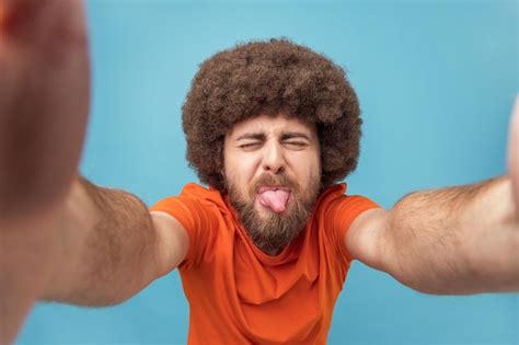 Premium Photo | Cheerful childish man taking selfie with closed eyes ...