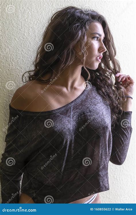 A Lovely Brunette Lingerie Model Poses in a Home Environment Stock