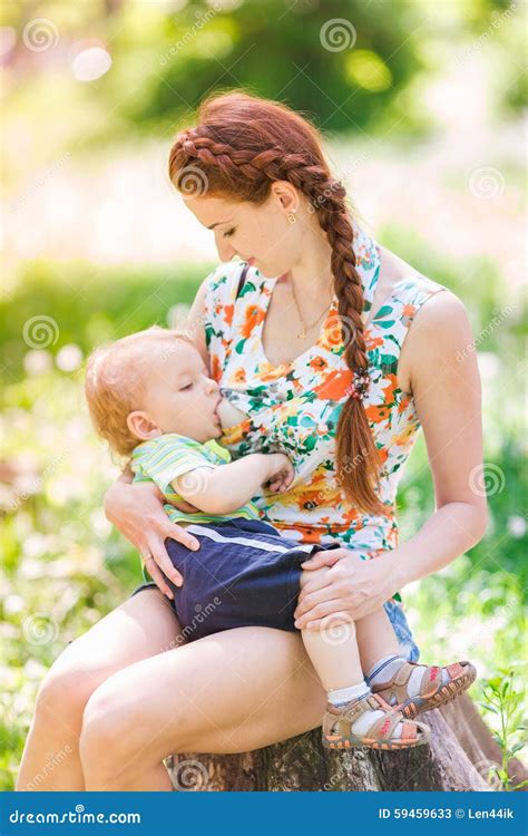 beautiful happy mother breastfeeding outdoor stock photography