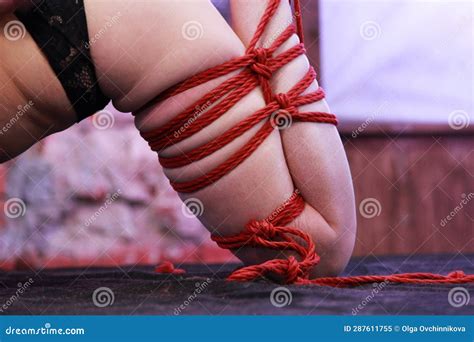 Leg of a Beautiful Girl Tied with Red Rope. Shibari Performance