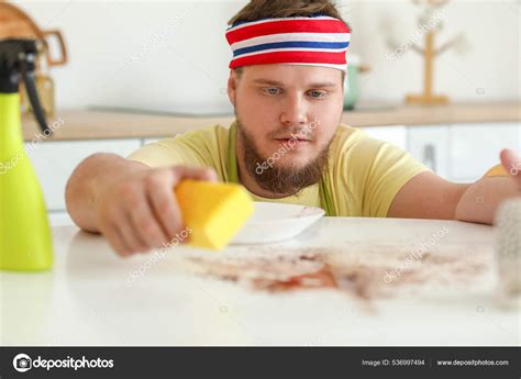 Young Man Sponge Cleaning Dining Table Kitchen Stock Photo by ©serezniy 536997494