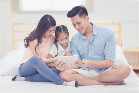 Happy family in the bedroom,Asian father and mother watching cartoon