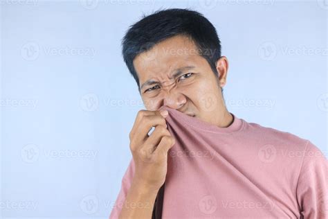Asian man check his own smell, sniffing his wet armpit or sweating