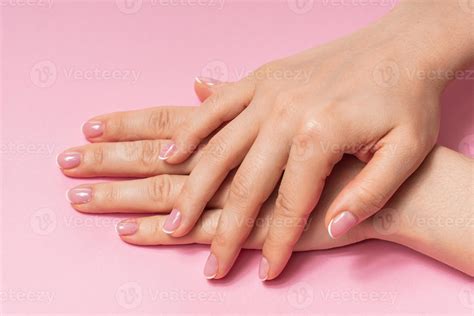 Female hands with soft skin and beautiful french manicure against pink ...