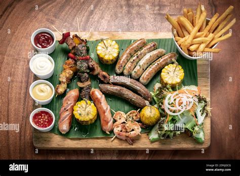 organic mixed grill barbecue meat platter rustic set meal with sausages, skewers, side dishes ...