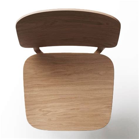 a wooden chair that is sitting up against a white wall with no one ...