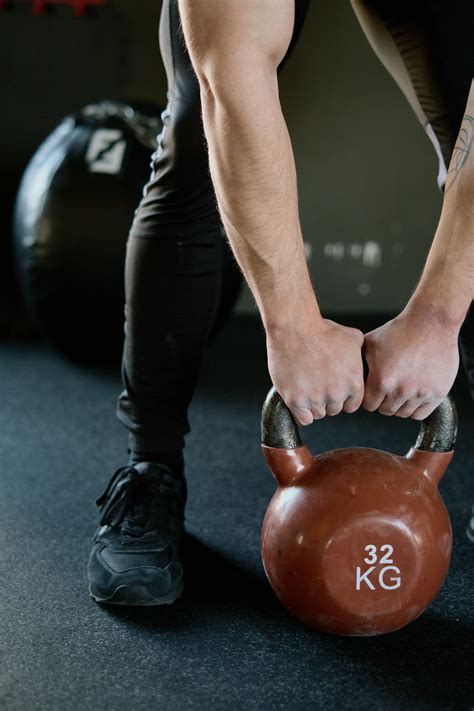 Person Holding Red KettlebellFree Stock Photo