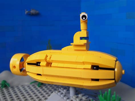 a lego model of a yellow submarine in front of a blue wall
