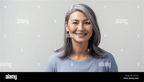 Beautiful Mature Asian Woman Smiles Broadly In Studio. Right Side