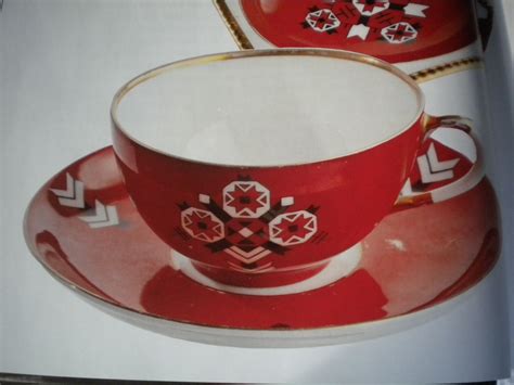 an open book with two red cups and saucers on top of each other,