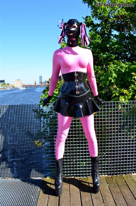 Rubber doll posing posing outside in boots, catsuit, tutu, corset