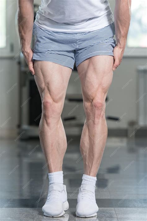 premium photo muscular athlete flexing leg muscles closeup