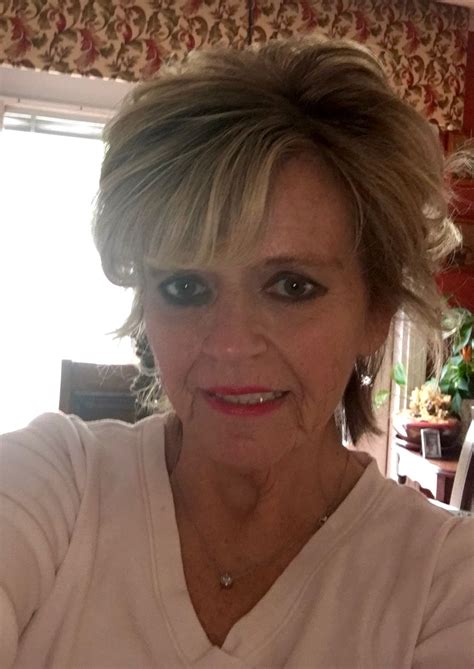 an older woman is taking a selfie in the mirror