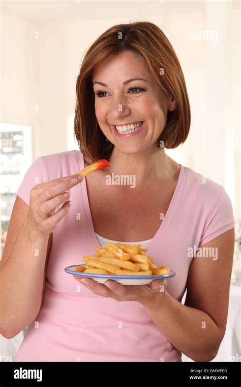 WOMAN EATING FRENCH FRIES Stock Photo - Alamy