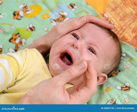 The Woman Digs in Drops in a Nose To the Sick Crying Baby Stock Photo ...