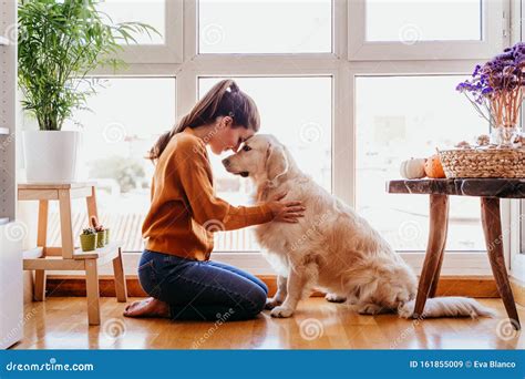 Beautiful Woman Hugging Her Adorable Golden Retriever Dog at Home. Love for Animals Concept ...