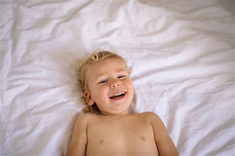 Smiling Baby Girl on a Bed · Free Stock Photo