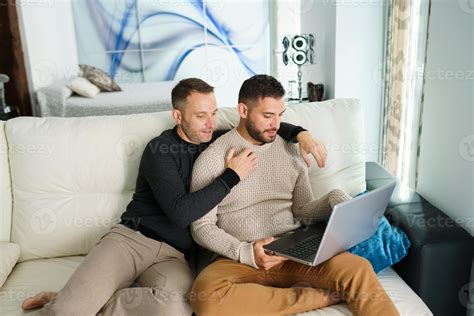 Couple of men watching movie on laptop at home 10970724 Stock Photo at