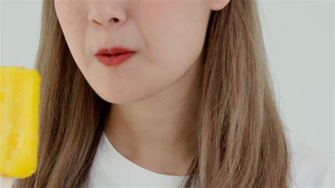 Asian woman feel sensitive teeth after eating ice cream, female suffer