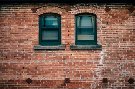 Detail of aged brick building with windowsFree Stock Photo